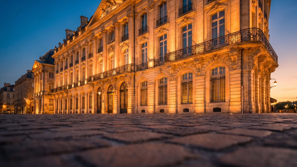 Berline de prestige avec chauffeur devant l'entrée d'un grand hôtel de Bordeaux
